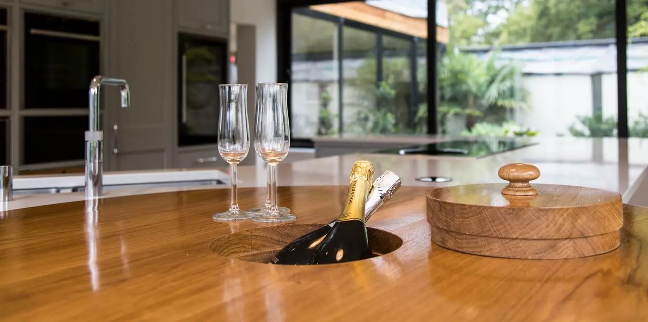 A polished wood worktop with an ice bucket recess