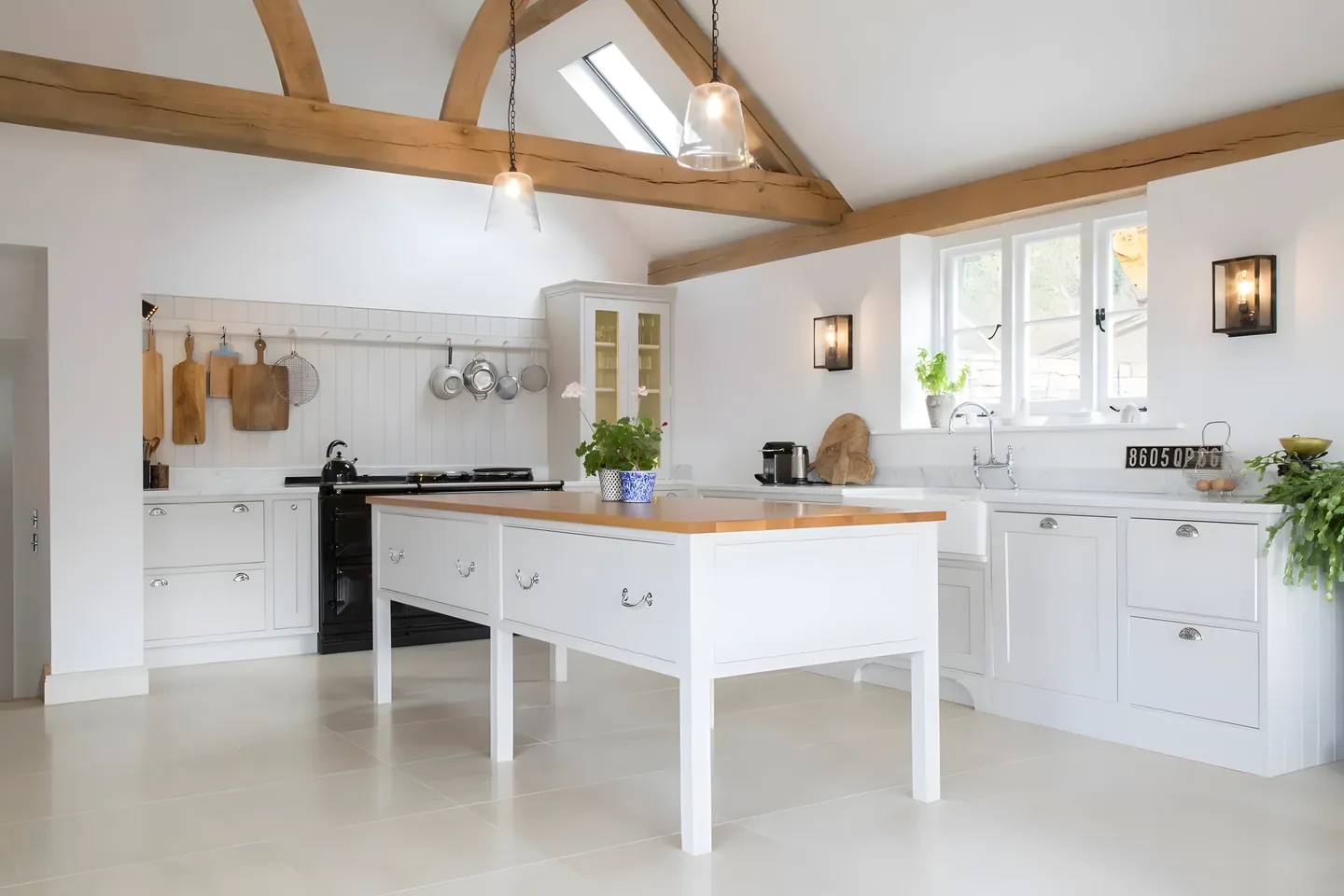 An oak-topped freestanding island in a bright beamed kitchen