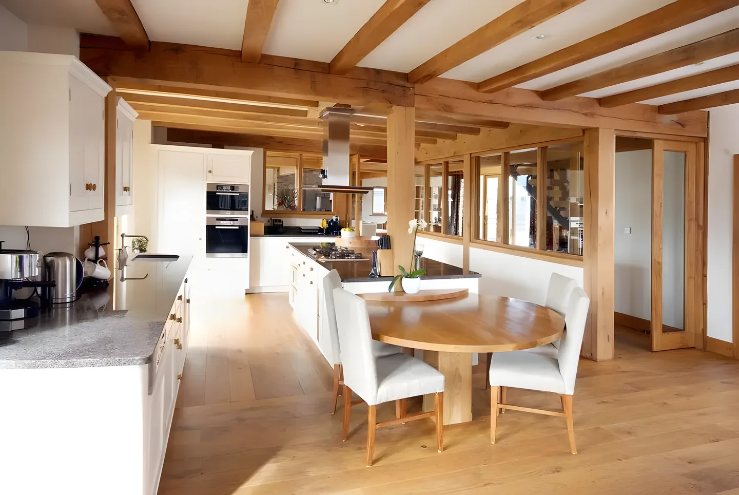 An open-plan oak kitchen and dining space with exposed timber frame
