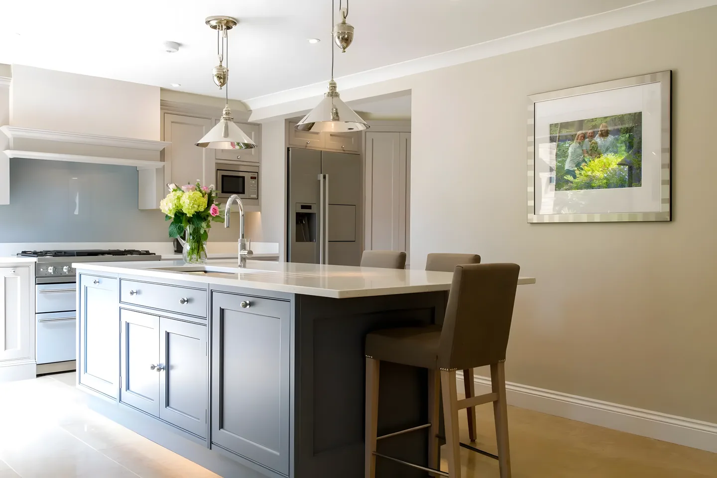 A slate-painted island with a stool and pendant lights