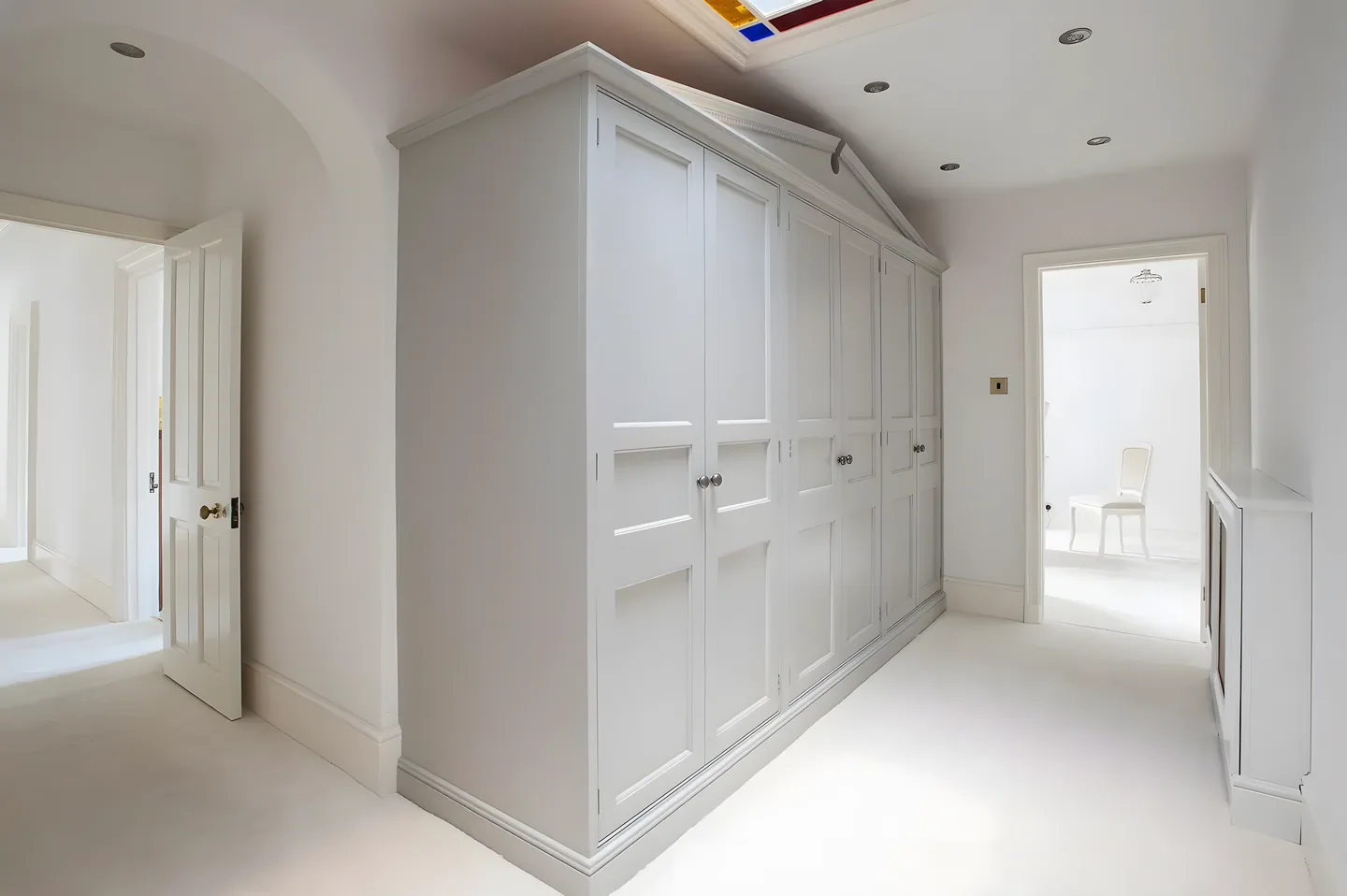 Tall painted fitted wardrobes in a hallway