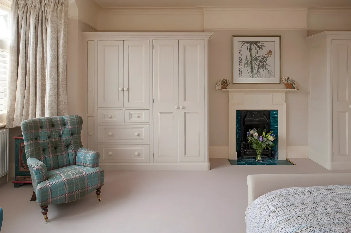 Cream wardrobes beside a fireplace